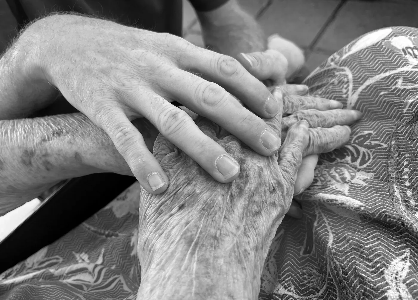 Zwei Generationen: eine jüngere Hand hält die Hände eines älteren Menschen