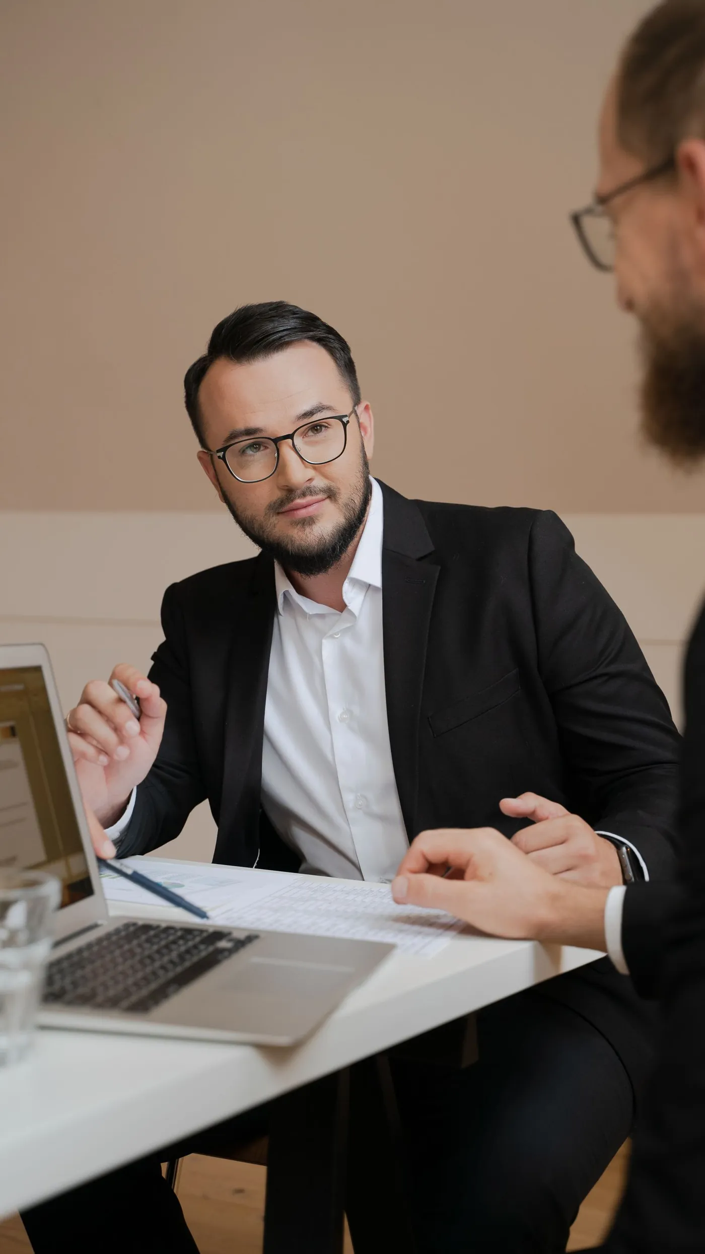 Beratungssituation: Berater erläutert einer Kundin Unterlagen am Laptop